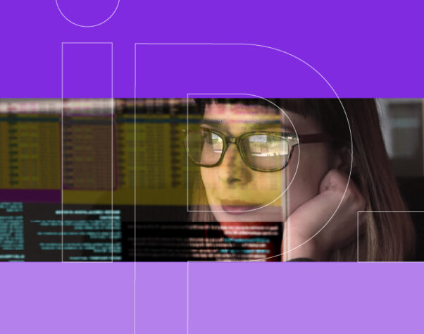A woman looks at a screen of code