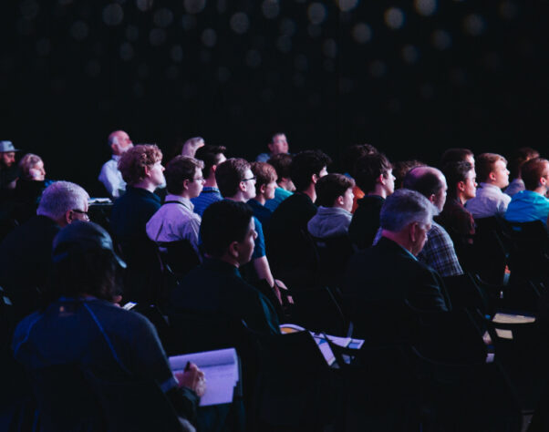 people sitting in a dark conference audience