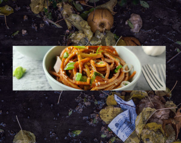 a bowl of appealing pasta on top of a pile of food waste