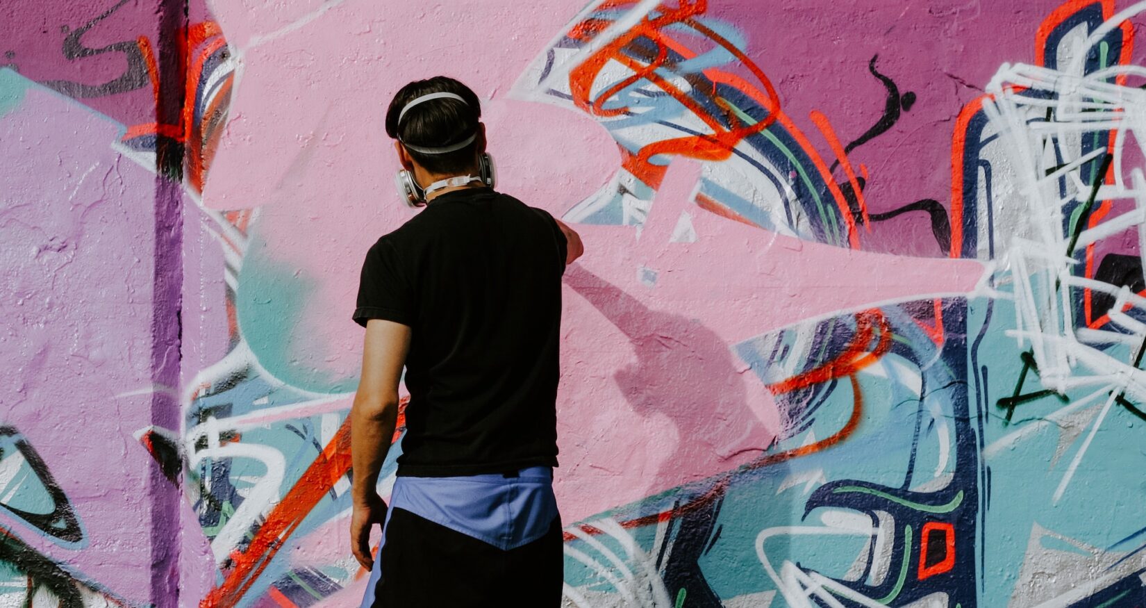 man doing graffiti art on a wall